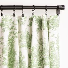 green and white toiler curtains hanging on a black rod