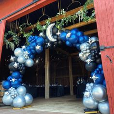 a large blue and silver balloon arch with stars and moon decorations on it's sides