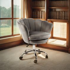 a gray office chair sitting in front of a window