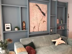 a living room filled with lots of furniture next to a wall mounted art piece on the wall