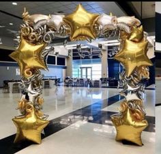 an arch made out of gold and silver foil stars in the middle of a room