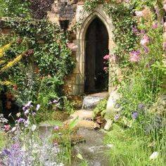 a garden with lots of flowers and plants growing around the building's doorways