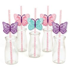 butterflies and striped straws in glass vases with paper straws on the top