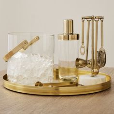 an assortment of glass and brass items on a tray with the words west elm written below it