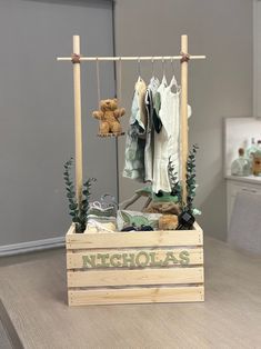 a wooden crate with clothes and teddy bears on it sitting on a table in a room