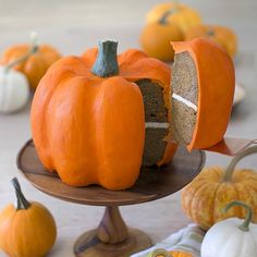 there is a cake that has been cut in half and placed on a plate with other pumpkins around it