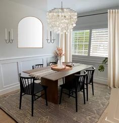 a dining room table with chairs and a chandelier hanging from it's ceiling