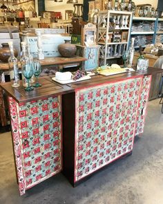 an old fashioned cabinet with glass vases on it in a room full of antiques