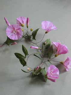 some pink flowers are on a white surface