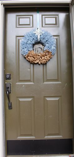 a door with a wreath on it and a star hanging from the top of it