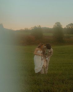 two people standing in the grass near each other