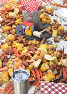 crab legs, corn on the cob, and potatoes are laid out on a table