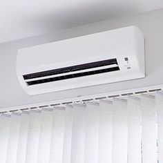 a white air conditioner sitting on top of a window