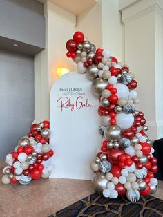 the balloon arch is decorated with red, white and silver balloons