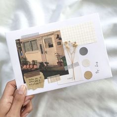 a person holding up an open photo book with pictures and words on it in front of a white bed sheet