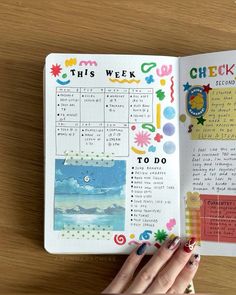 a woman's hand is holding an open planner book on a wooden table with the words, this week to do