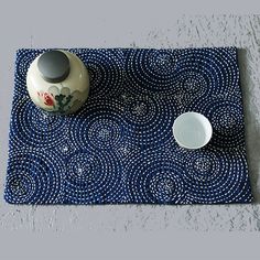 a blue place mat with two white bowls on it