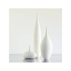 three white vases sitting on top of a table