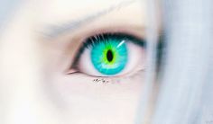 a woman's eye with green and blue iris