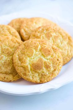 three biscuits on a white plate sitting on a table