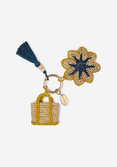 a keychain with a flower on it and a bag charm attached to it