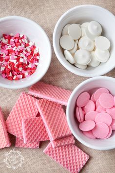 four bowls filled with candy and marshmallows on top of a table