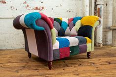 a multicolored couch sitting on top of a wooden floor