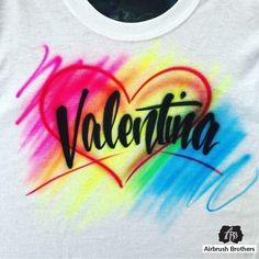 a white shirt with the word valentine written in black on it and a rainbow heart