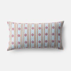 an orange and white striped pillow with red circles on it