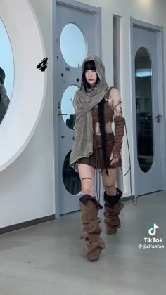 a woman dressed in costume and boots walking through a hallway with two mirrors behind her