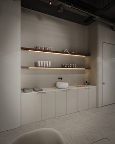 an empty room with shelves filled with cups and bowls on top of the countertop