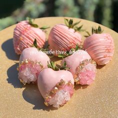 four pink strawberries with gold glitter on them