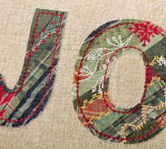 the word joy is made out of fabric and stitched into a piece of cloth