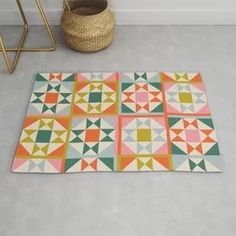 an area rug with different colored geometric designs on it and a basket next to it