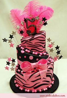 a three tiered cake with pink and black decorations