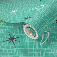 a green wallpaper with stars and shapes on the ground, as well as a roll of tape