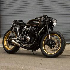 a black and gold motorcycle parked in front of a garage