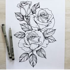 a drawing of three roses with leaves on paper next to two markers and a pen