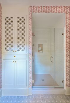 a walk in shower sitting next to a white cabinet