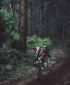 a person riding a dirt bike on a trail in the woods