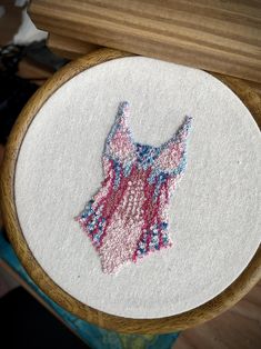 a close up of a embroidery on a wooden hoop