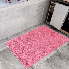 a bathroom with a pink rug on the floor