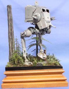 a star wars action figure on display in front of a blue background with trees and grass