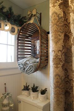 a bathroom with a toilet, mirror and christmas decorations on the window sill above it