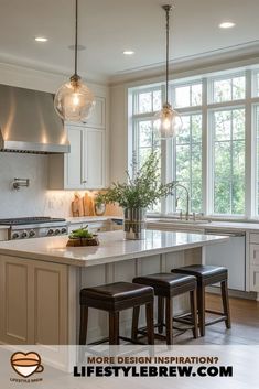 a kitchen island with stools and lights hanging from it's ceiling over the sink