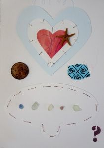 a heart shaped paper cut out with scissors and other crafting items around it on a white surface