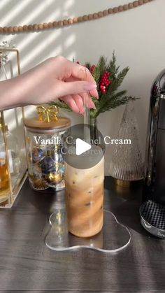 a person is making an iced drink in front of a coffee maker and christmas decorations