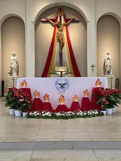 the altar is decorated with red and white flowers in front of a crucifix