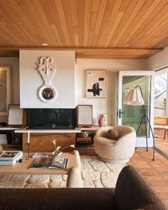 a living room filled with furniture and a flat screen tv mounted to the wall next to a fire place