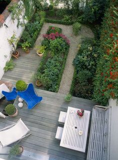 an aerial view of a patio with chairs and tables in the center, surrounded by greenery